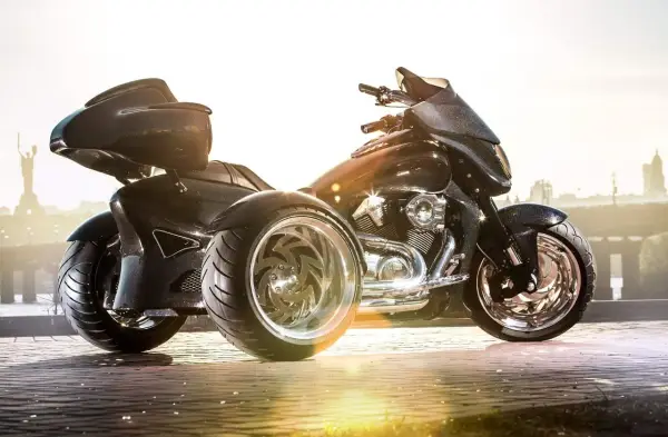 Czarny, lśniący motocykl trzykołowy z chromowanymi felgami, gotowy do podróży.